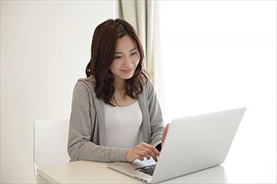 笑顔でパソコンを操作する女性